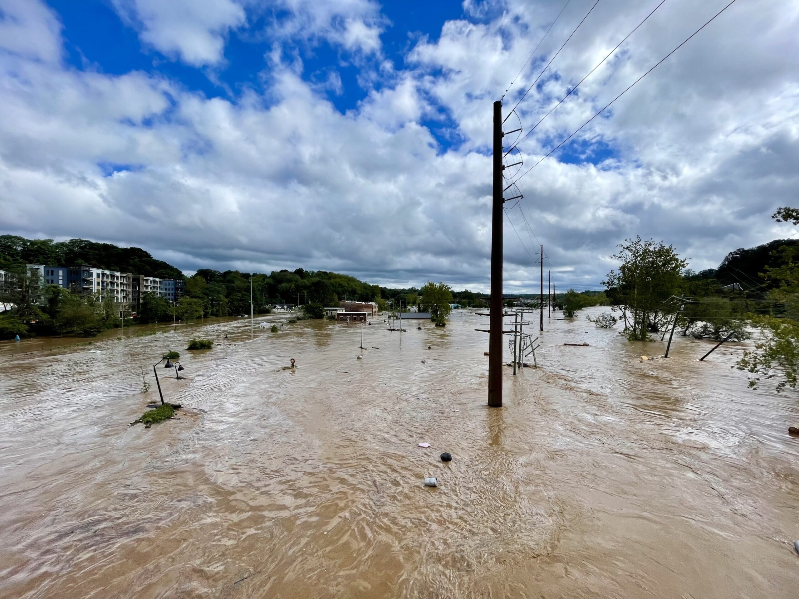 Image of the French Broad River flooded by the rain from Hurricane Helene in Asheville, NC's River Arts District.